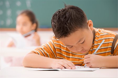 studying young asian boy - Boy writing on a notepad in a classroom Stock Photo - Premium Royalty-Free, Code: 625-02933068