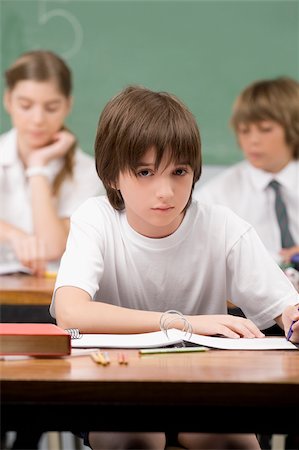 Schoolboy sitting in a classroom Foto de stock - Sin royalties Premium, Código: 625-02933155