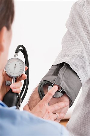 simsearch:700-00022316,k - Doctor checking a patient's blood pressure Stock Photo - Premium Royalty-Free, Code: 625-02933180