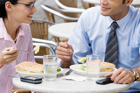 people eating at work - Businessman and a businesswoman having lunch at a sidewalk cafe Stock Photo - Premium Royalty-Free, Code: 625-02933216