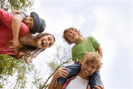 Parents carrying their children piggyback, Munich, Bavaria, Germany Stock Photo - Premium Royalty-Free, Code: 628-05817212