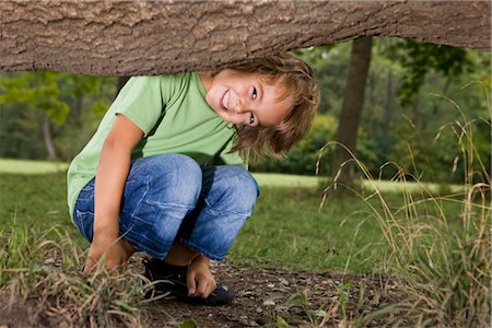 Smiling boy under tree trunk, Munich, Bavaria, Germany Stock Photo - Premium Royalty-Free, Code: 628-05817254