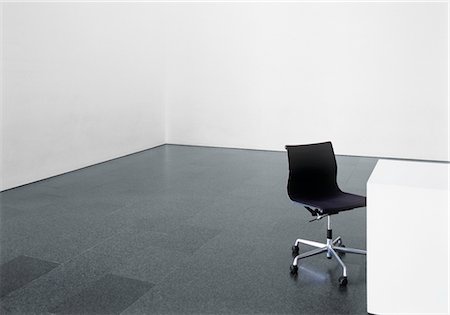 Office chair and desk in an empty room Foto de stock - Sin royalties Premium, Código: 628-05817457