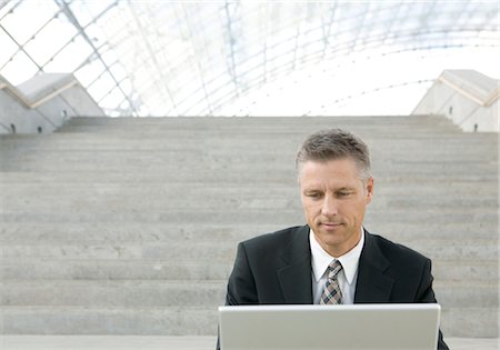 simsearch:628-05817499,k - Homme d'affaires assis sur les escaliers, à l'aide d'ordinateur portable Photographie de stock - Premium Libres de Droits, Code: 628-05817499