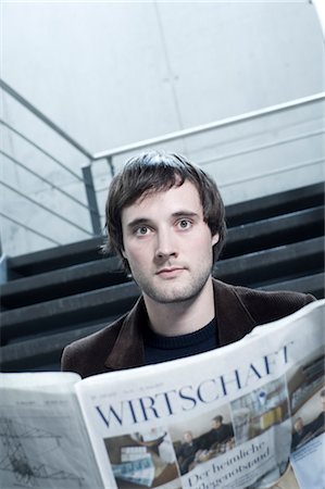 simsearch:649-06352545,k - Young man in staircase reading newspaper Stock Photo - Premium Royalty-Free, Code: 628-05817512