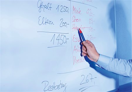 Financial advisor at whiteboard calculating home finances Stock Photo - Premium Royalty-Free, Code: 628-05817538