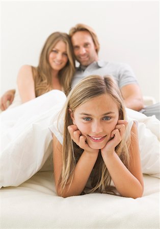 Smiling girl in bed of her parents Foto de stock - Sin royalties Premium, Código: 628-05817568