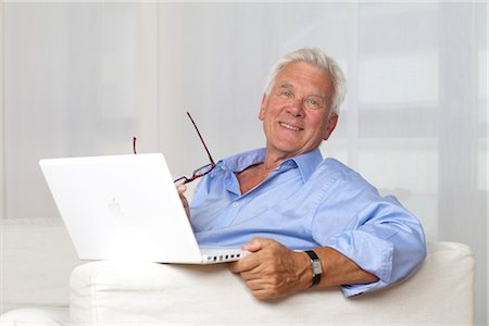 Smiling senior man using laptop at home Foto de stock - Sin royalties Premium, Código: 628-05817563