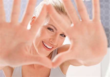 Happy woman looking through hands Stock Photo - Premium Royalty-Free, Code: 628-05817602