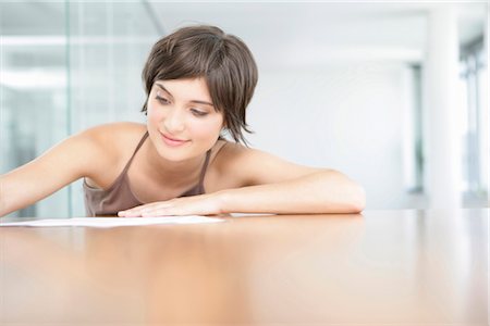 Woman writing a letter in a modern office Stock Photo - Premium Royalty-Free, Code: 628-05817631