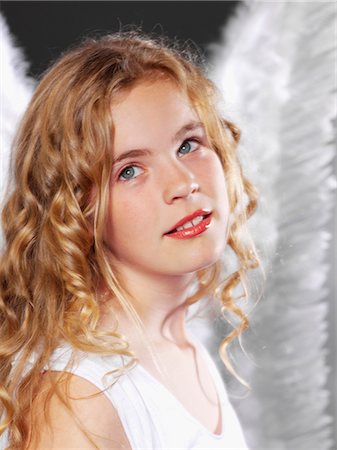 preteen in lipstick - Girl with curly hair wearing angel wings Foto de stock - Sin royalties Premium, Código: 628-05817796