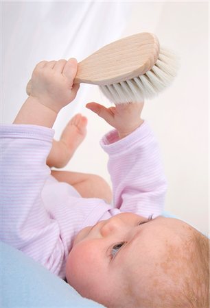 Baby holding hair brush Foto de stock - Sin royalties Premium, Código: 628-05817798