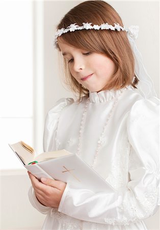 embroidering - Girl wearing Holy Communion dress holding bible Foto de stock - Sin royalties Premium, Código: 628-05817838