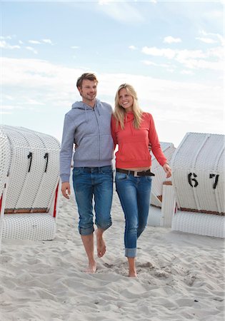 Couple walking on beach between beach chairs Stock Photo - Premium Royalty-Free, Code: 628-05817886