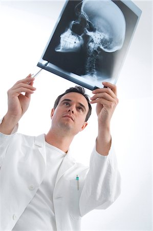 doctor looking at xray - Doctor is looking at a radiography Stock Photo - Premium Royalty-Free, Code: 628-05818019