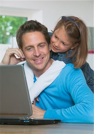 snuggling father - Father and son sitting in front of a laptop Stock Photo - Premium Royalty-Free, Code: 628-05818035