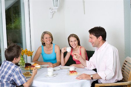 Family drinking coffee and eating cake on terrace, Munich, Bavaria, Germany Stock Photo - Premium Royalty-Free, Code: 628-05818119