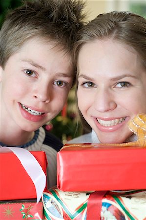 fun teenagers gifting - Happy brother and sister with Christmas presents, Munich, Bavaria, Germany Stock Photo - Premium Royalty-Free, Code: 628-05818124