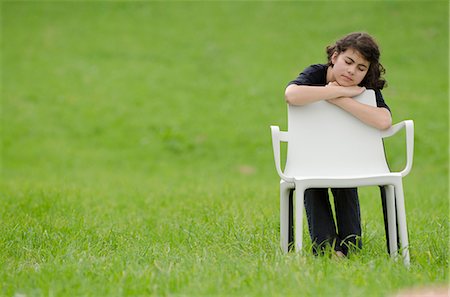 Girl with plastic chair in meadow sleeping Foto de stock - Sin royalties Premium, Código: 628-07072123