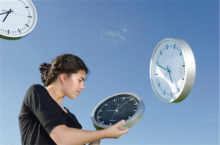 simsearch:400-03920699,k - Girl holding clocks outdoors Photographie de stock - Premium Libres de Droits, Code: 628-07072132