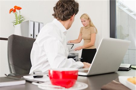 secretary on chair in office - Businessman looking at woman using photocopier Stock Photo - Premium Royalty-Free, Code: 628-07072140