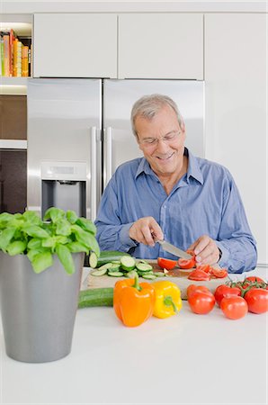 simsearch:6108-06166729,k - Senor man slicing vegetables in kitchen Foto de stock - Sin royalties Premium, Código: 628-07072157