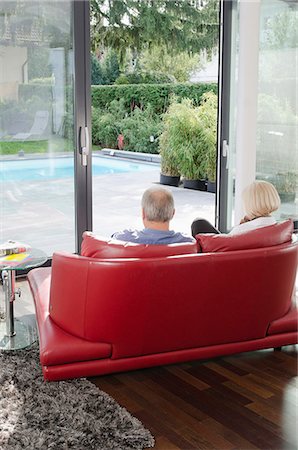 red open house door - Senior couple on couch looking out to swimming pool Stock Photo - Premium Royalty-Free, Code: 628-07072165