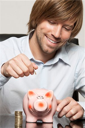 stack white shirt - Man putting coin into piggy bank Stock Photo - Premium Royalty-Free, Code: 628-07072206