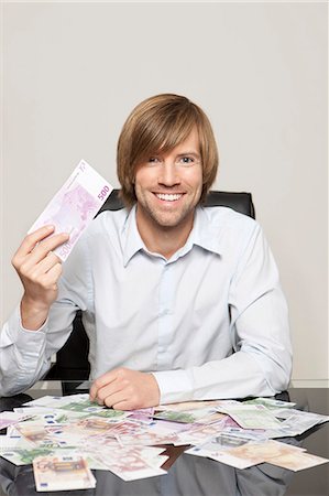 euro currency picture - Happy man at desk with Euro notes Stock Photo - Premium Royalty-Free, Code: 628-07072202