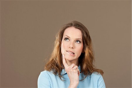 Young woman in blue polo shirt thinking Photographie de stock - Premium Libres de Droits, Code: 628-07072244