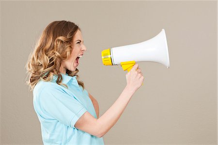 Young woman screaming into megaphone Stock Photo - Premium Royalty-Free, Code: 628-07072273