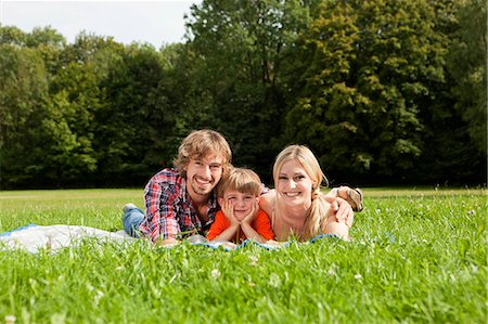 portrait of family lying down side by side - Happy family lying on blanket in meadow Stock Photo - Premium Royalty-Free, Code: 628-07072292