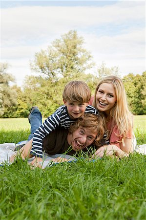 Happy family lying on blanket in meadow Foto de stock - Sin royalties Premium, Código: 628-07072302