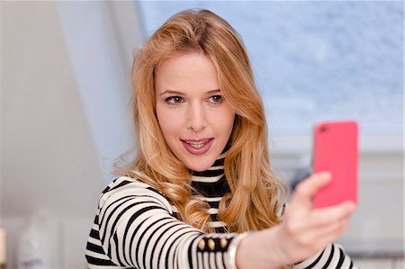 selfie cell phone indoor - Blond young woman taking self portrait with cell phone Stock Photo - Premium Royalty-Free, Code: 628-07072331