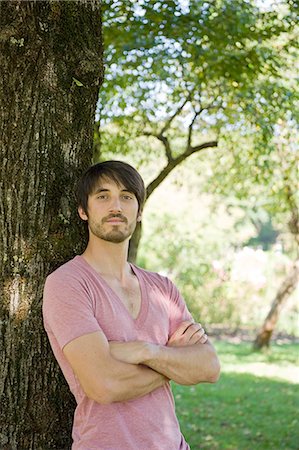 pink summer not flower - Man with arms folded leaning against tree Stock Photo - Premium Royalty-Free, Code: 628-07072347