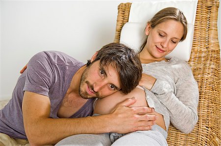 pregnant couple couch - Man listening at stomach of pregnant woman Photographie de stock - Premium Libres de Droits, Code: 628-07072340