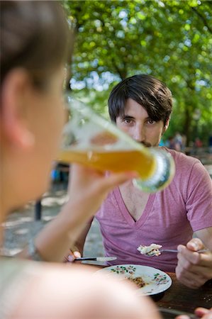 simsearch:6115-07109843,k - Man looking at woman drinking beer in beer garden Stock Photo - Premium Royalty-Free, Code: 628-07072361