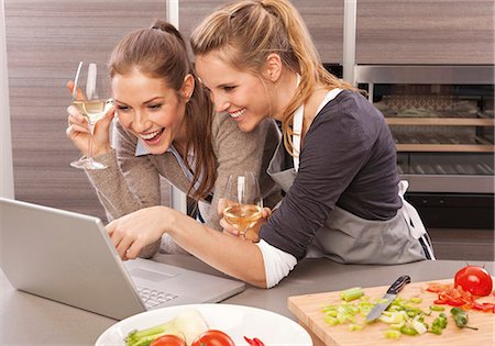 drinking wine in home - Two happy young women using laptop in kitchen Stock Photo - Premium Royalty-Free, Code: 628-07072517