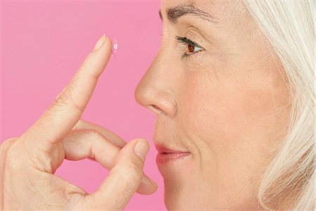 Mature woman putting contact lenses in Foto de stock - Sin royalties Premium, Código: 628-07072520