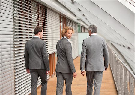 simsearch:6113-06753511,k - Three businessmen walking on corridor Stock Photo - Premium Royalty-Free, Code: 628-07072537