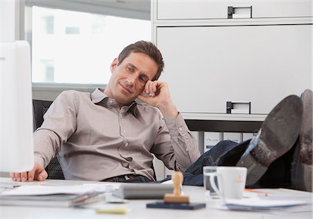 simsearch:628-07072186,k - Businessman sitting at desk with feet up Foto de stock - Sin royalties Premium, Código: 628-07072531