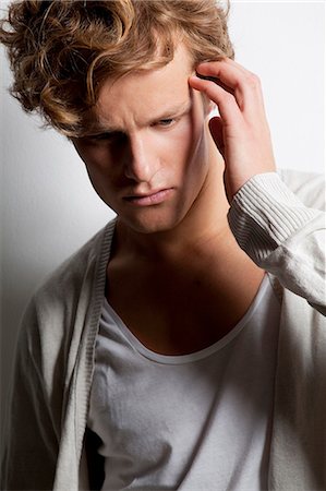 scratching head - Pensive young man with curly hair Stock Photo - Premium Royalty-Free, Code: 628-07072563