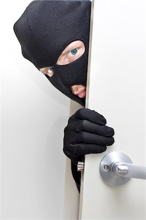 danger - Burglar peering around the corner of a door Stock Photo - Premium Royalty-Free, Code: 628-07072658