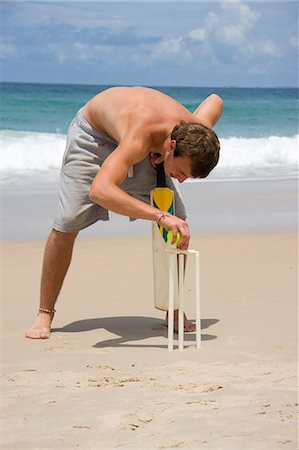 Young man playing cricket on the beach Fotografie stock - Premium Royalty-Free, Codice: 628-07072653