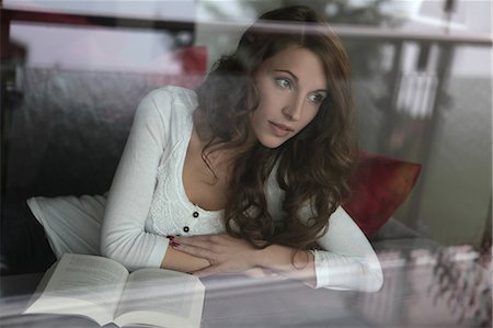 Brunette young woman looking away from book Stock Photo - Premium Royalty-Free, Code: 628-07072700