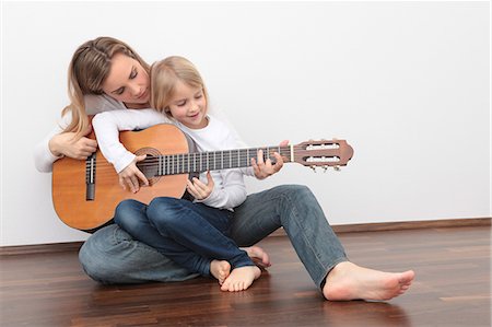 simsearch:400-04344925,k - Daughter playing guitar on mother's lap Stock Photo - Premium Royalty-Free, Code: 628-07072734