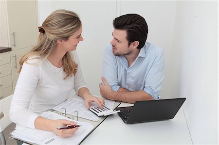 pay with device - Man and woman sitting at table with file, calculator and laptop Stock Photo - Premium Royalty-Free, Code: 628-07072747