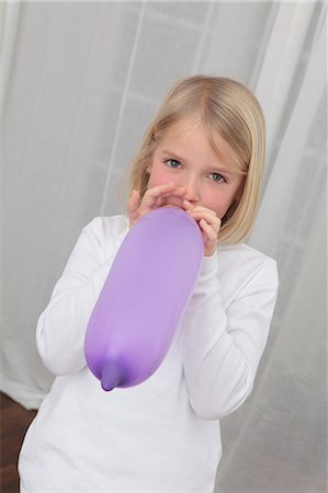 preparing party home - Blond girl blowing balloon Stock Photo - Premium Royalty-Free, Code: 628-07072740