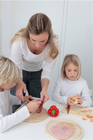 Mother and two children preparing meal Stock Photo - Premium Royalty-Free, Code: 628-07072741