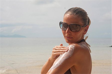 simsearch:649-08479729,k - Woman on beach applying suntan lotion, Thailand Stock Photo - Premium Royalty-Free, Code: 628-07072967